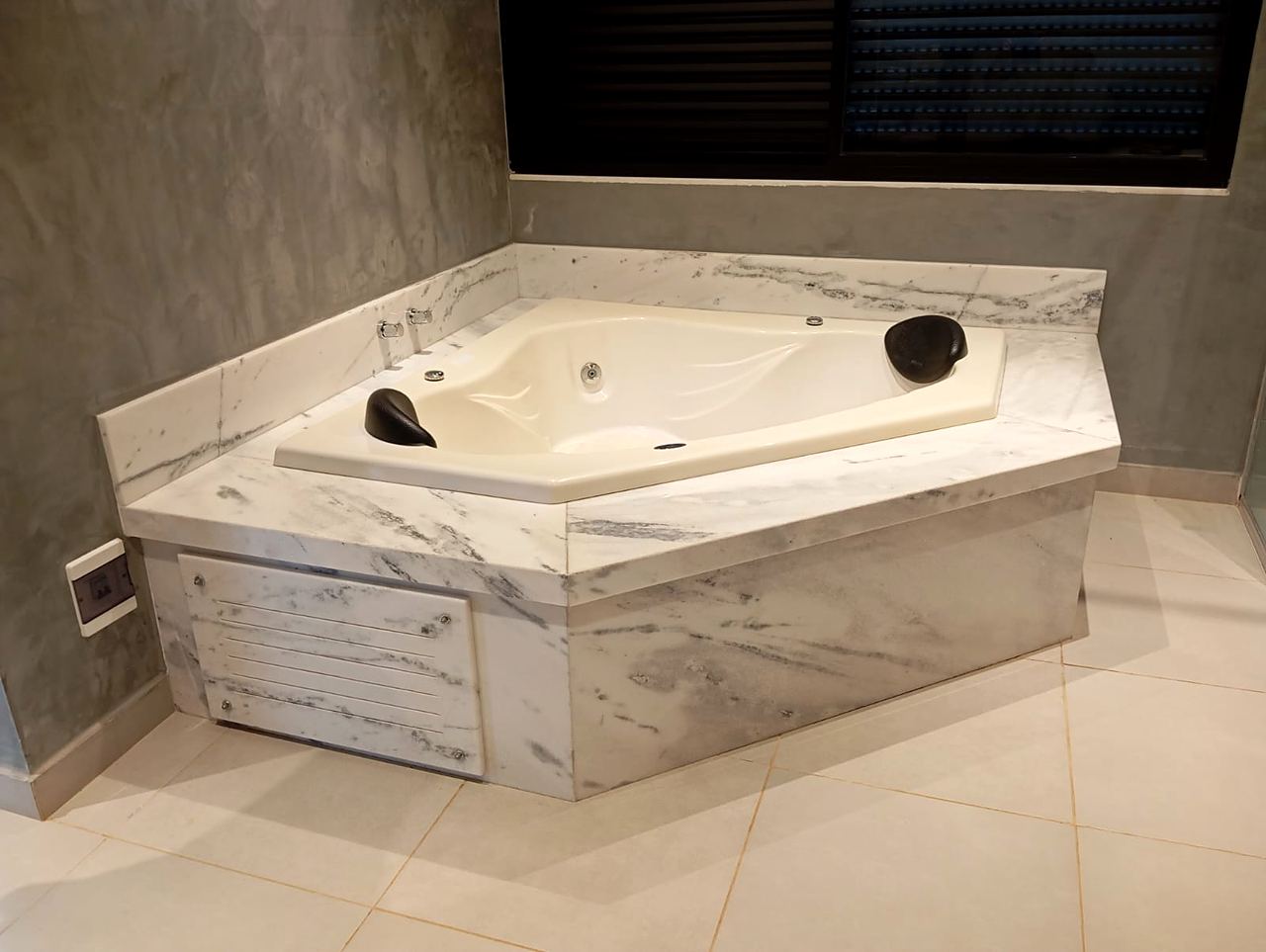 Banheira de hidromassagem de canto revestida em mármore branco