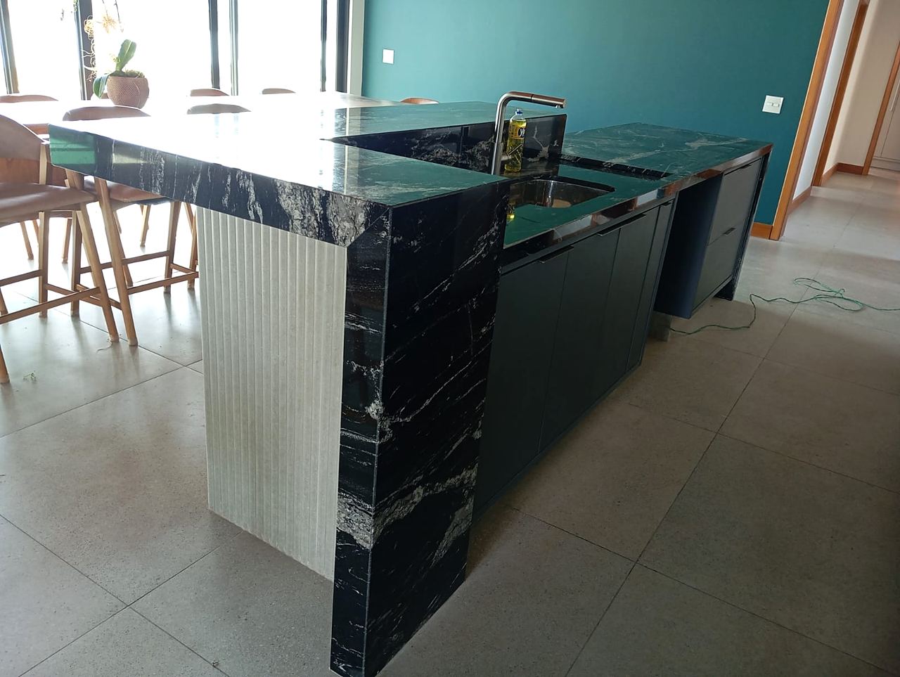 Ilha em granito Preto Via Láctea com cuba de inox, torneira e cascata sobre ripado