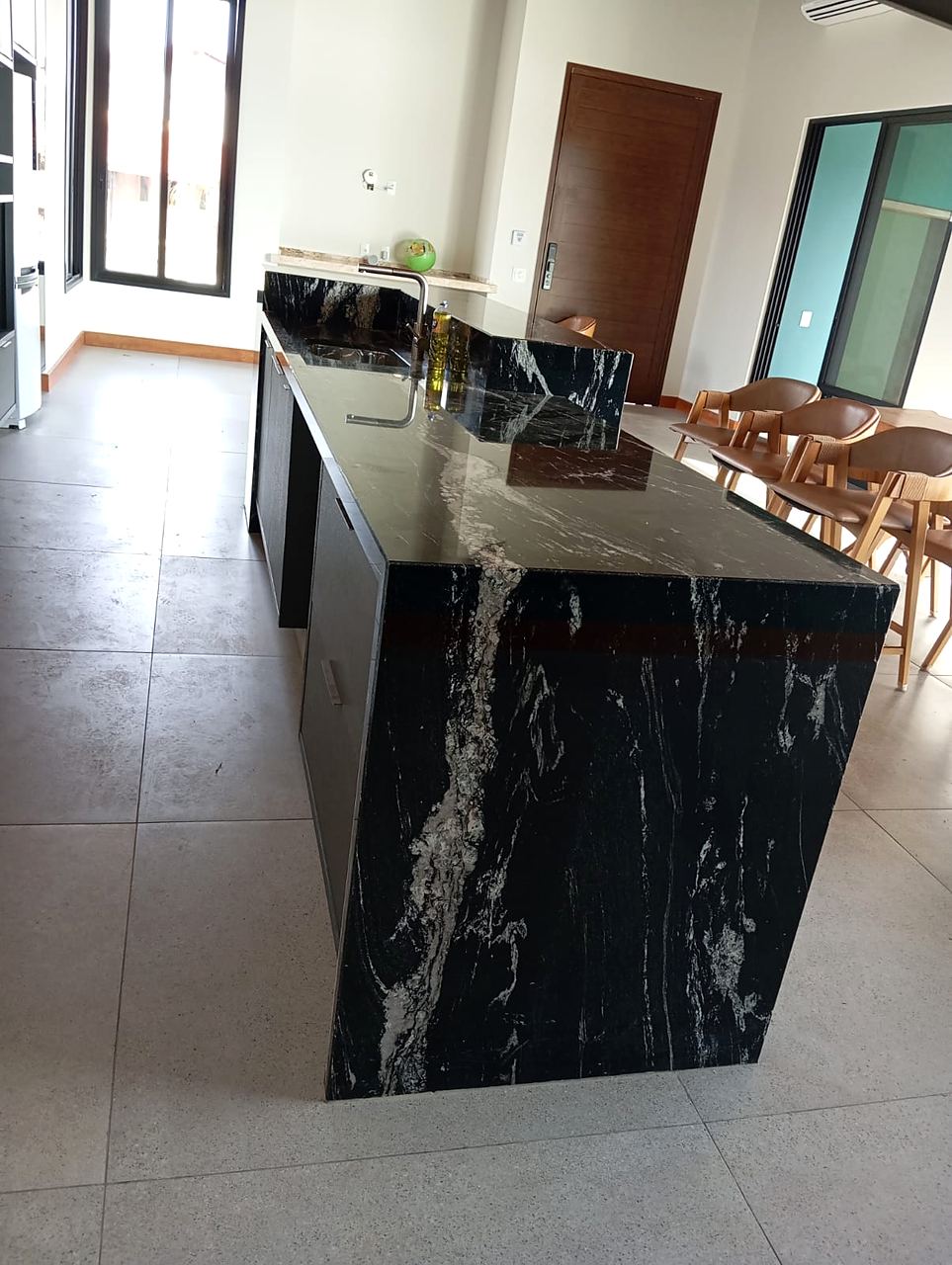 Ilha de cozinha com cascata em granito Preto Via Láctea, veios brancos descendo pela lateral