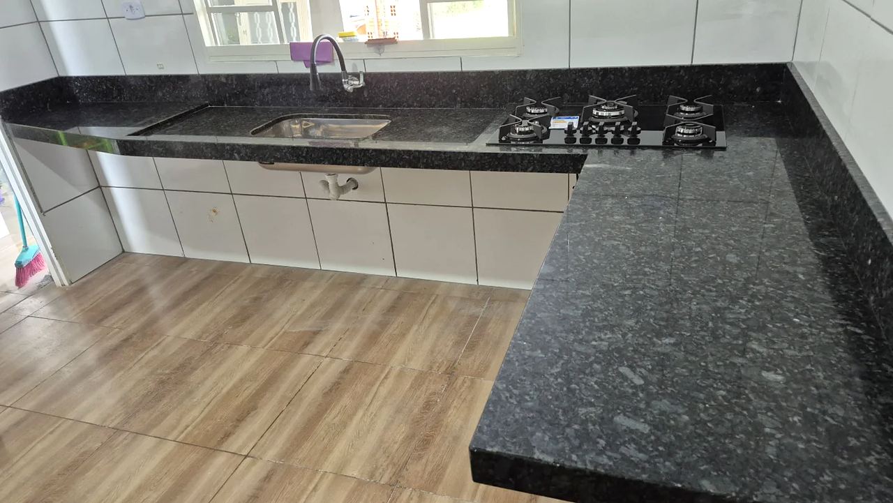 Bancada em L de granito Verde Ubatuba com cuba e cooktop